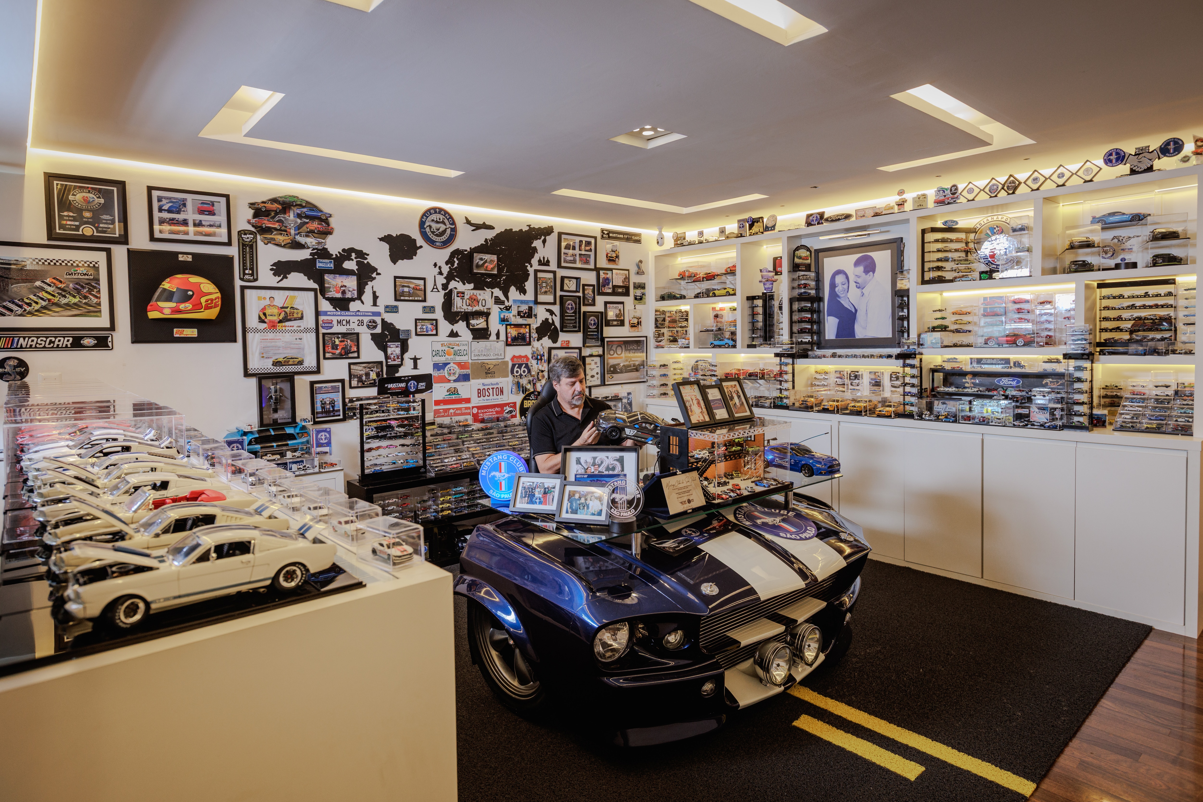 Carlos Cosentino em sua sala temática com as miniaturas do Ford Mustang e sua coleção de itens que remetem ao muscle car